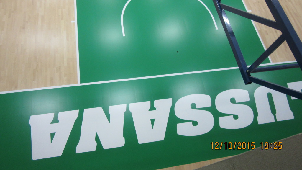 Il nuovo parquet sportivo della palestra del liceo di Bergamo è stato personalizzato con la scritta "Lussana" in bianco su vernice verde