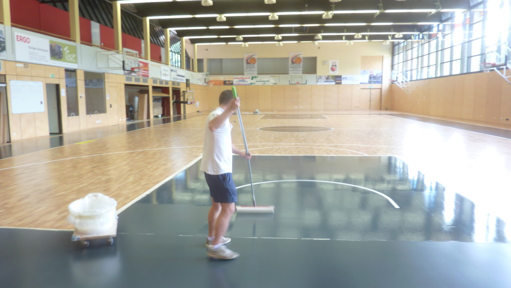 Tecnici Dalla Riva Sportfloors durante le fasi di colorazione delle aree di basket dell'impianto tedesco